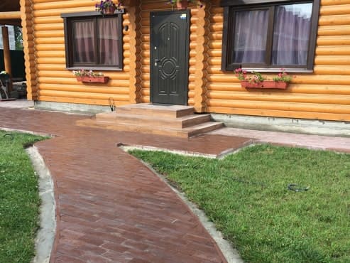 Вібролита плитка з фактурою дерева ідеально підійшла до будинку зі зрубу